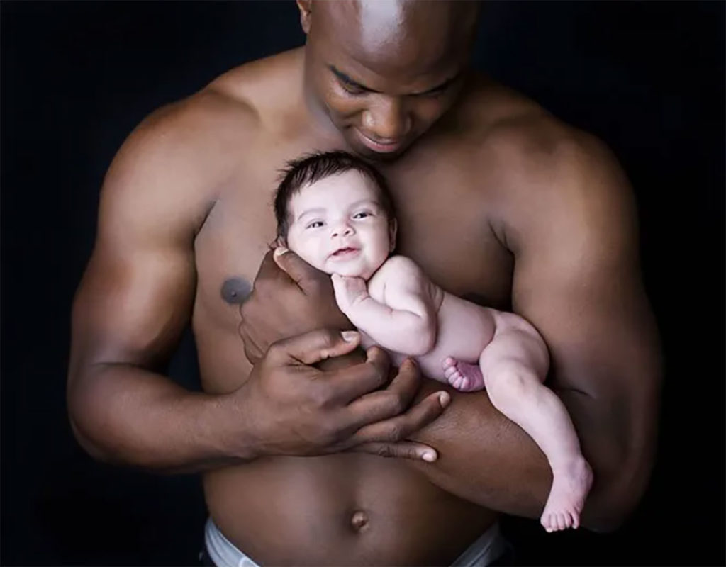 Homme noir portant un enfant blanc dans ses bras