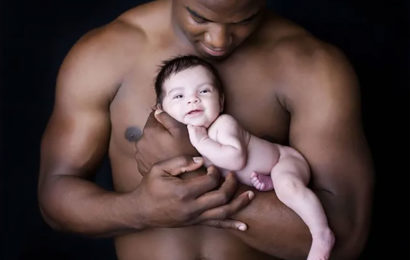 Homme noir portant un enfant blanc dans ses bras